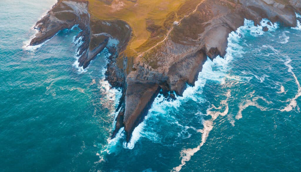 Bovenaanzicht van kliffen in de zee tijdens zonsondergang in Portugal